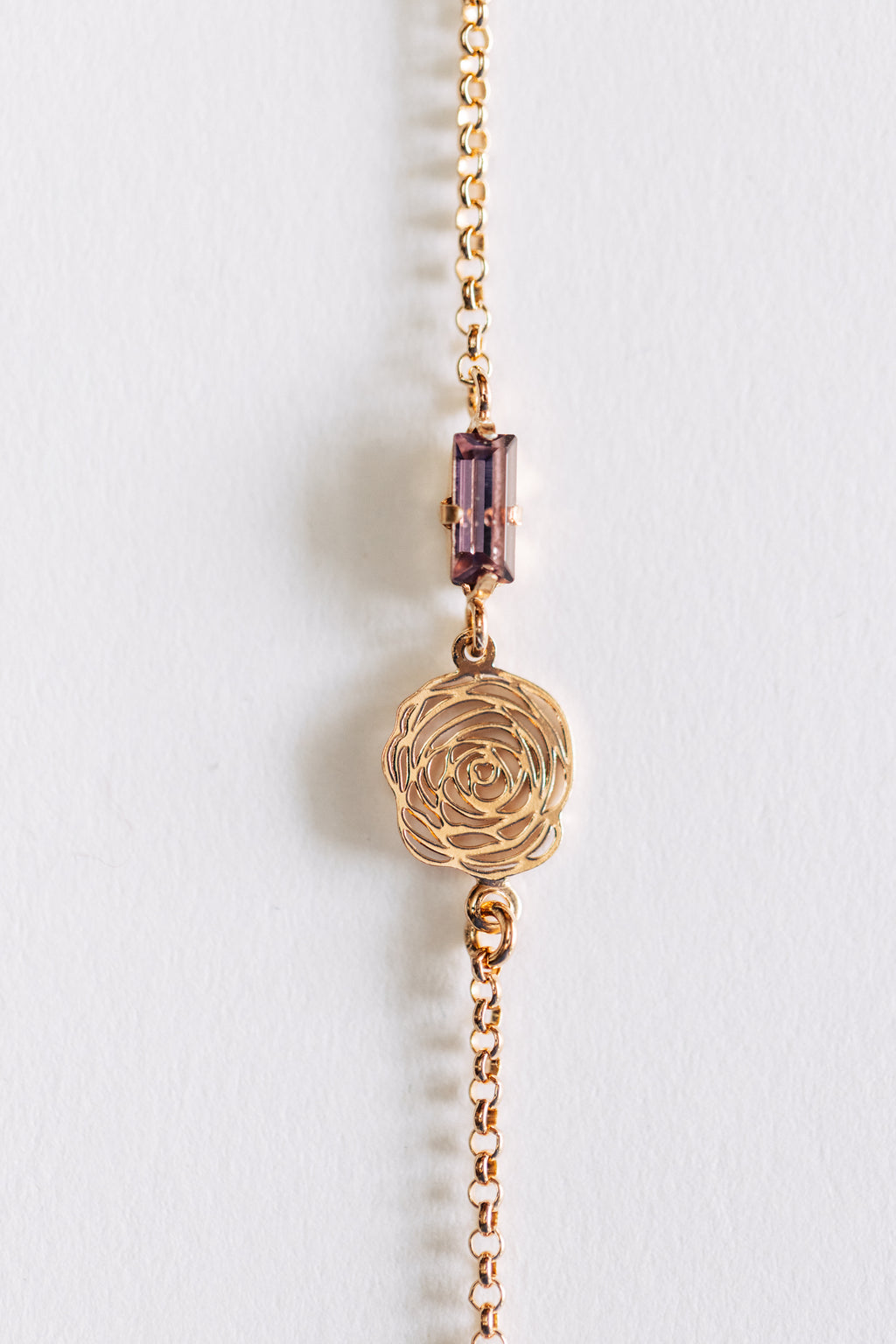 A hypoallergenic rose gold bracelet with a solid pattern and a central decorative element, displayed against a white background.