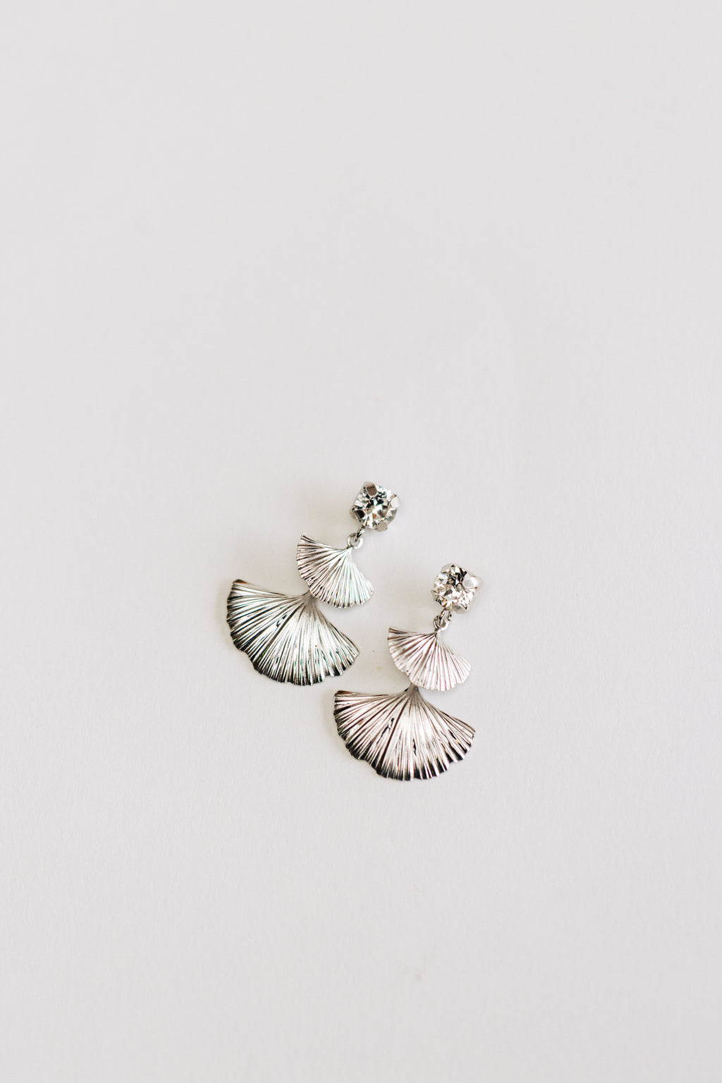 This image displays a pair of hypoallergenic elegant silver earrings, named "Mia earrings." The design features a delicate fan design.