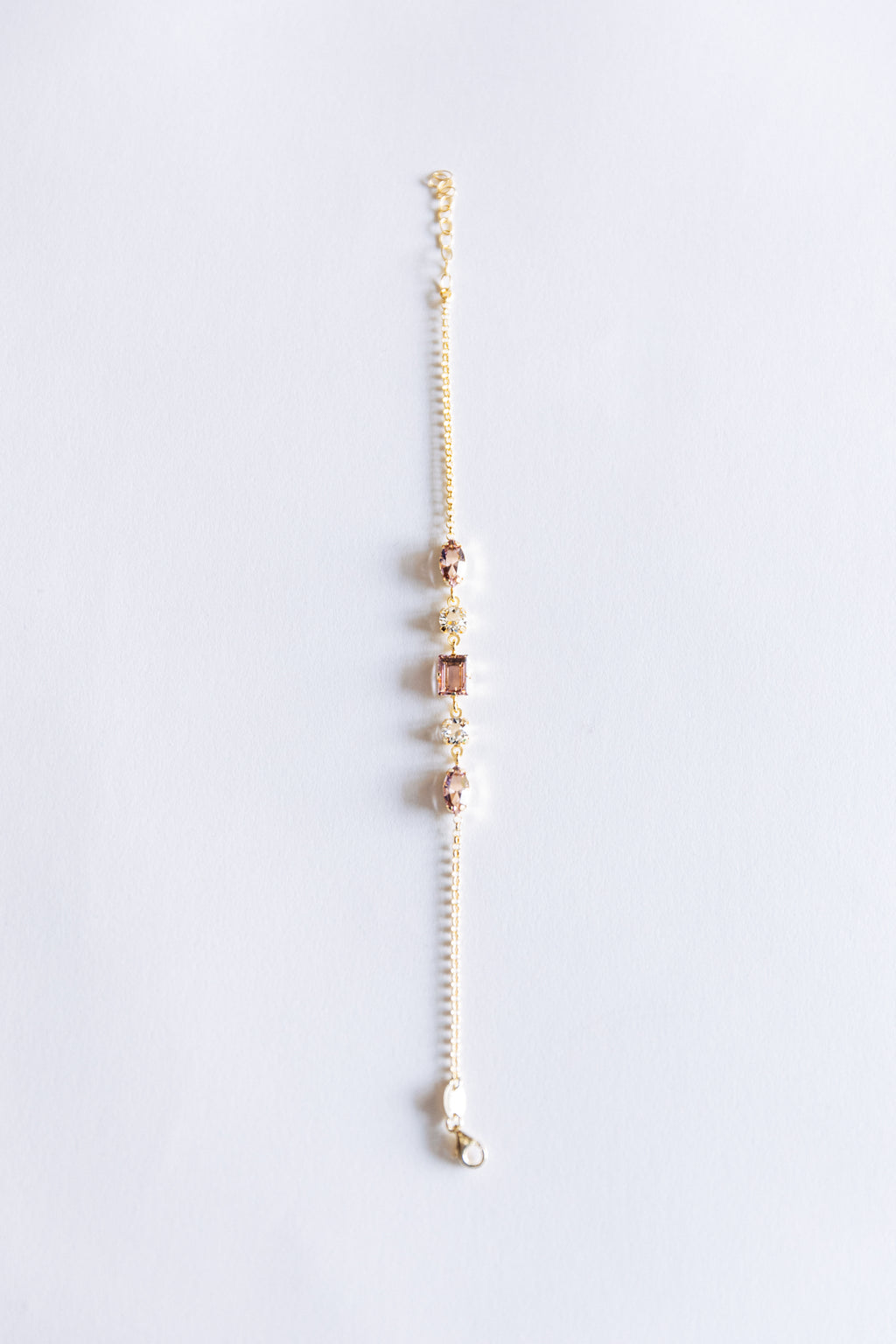 A rose gold bracelet with small crystals, displayed against a white background.