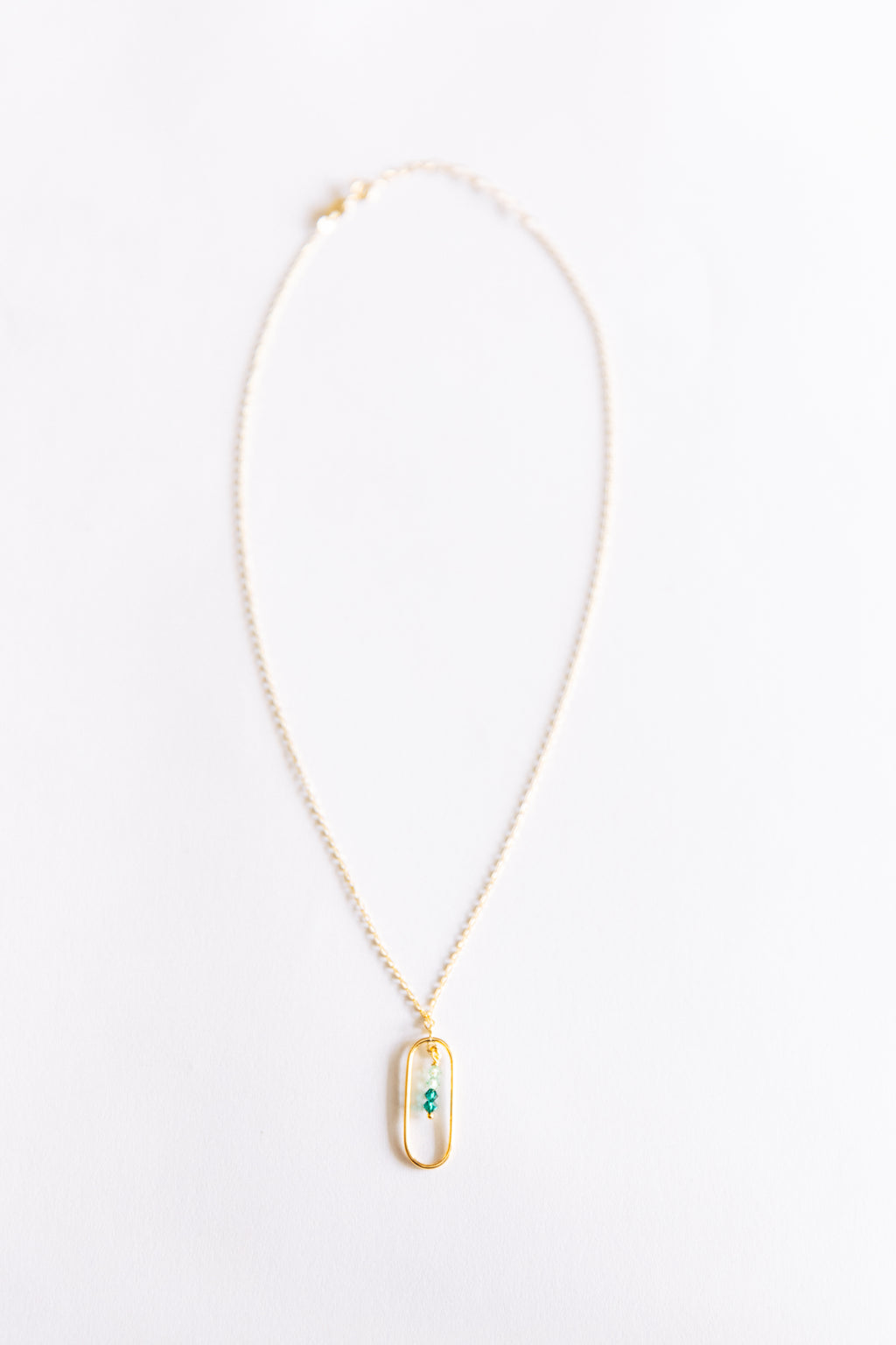 Gold necklace with a pendant on a white background