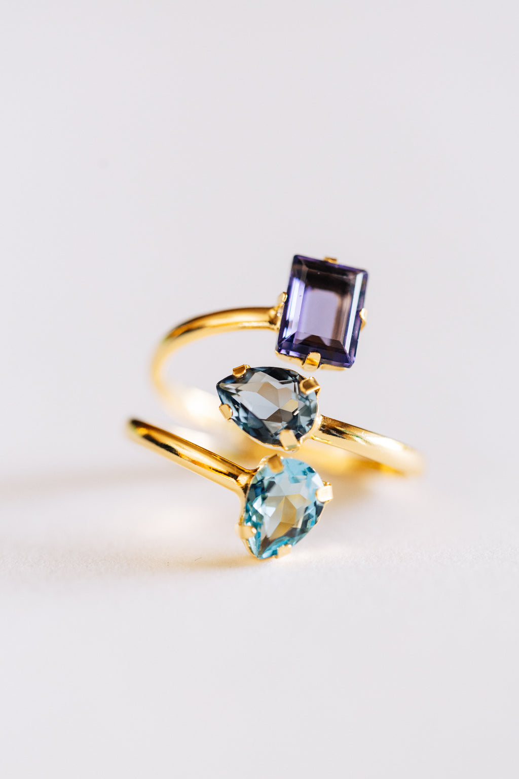 Gold ring with multi-coloured crystals on a light background